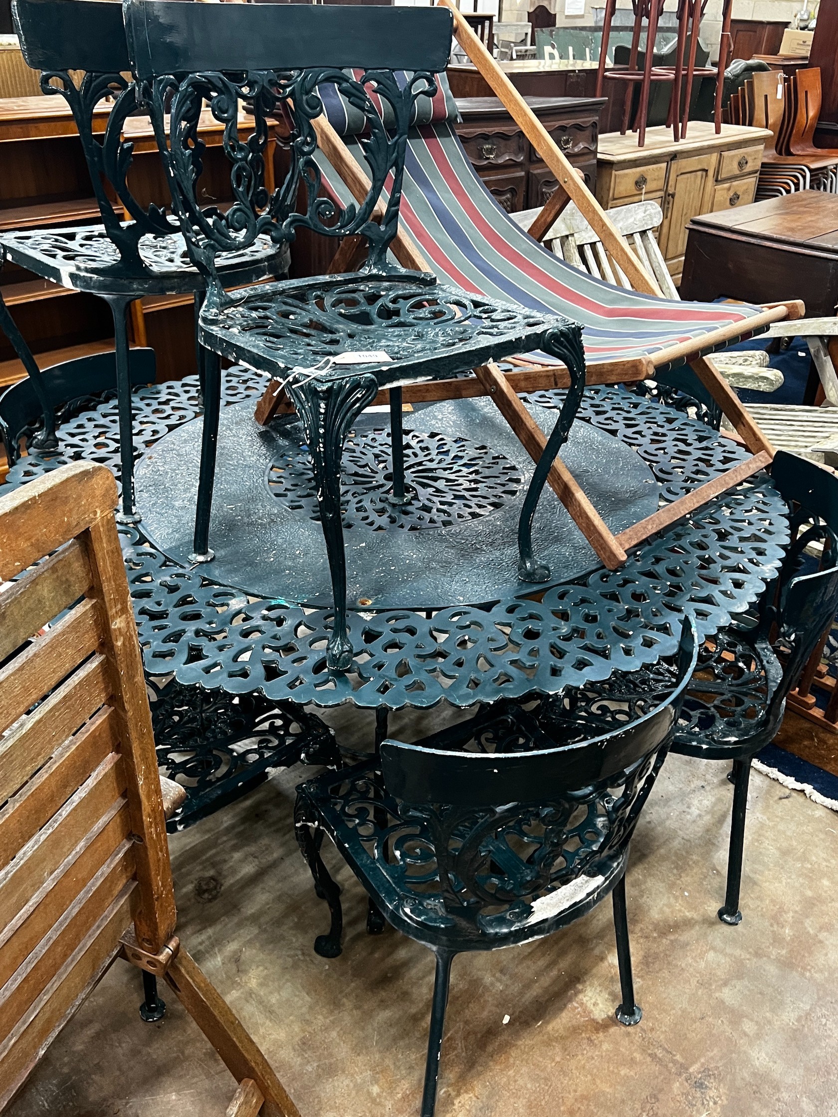 A Victorian style circular aluminium garden table and eight aluminium garden chairs, table 142cm diameter height 71cm